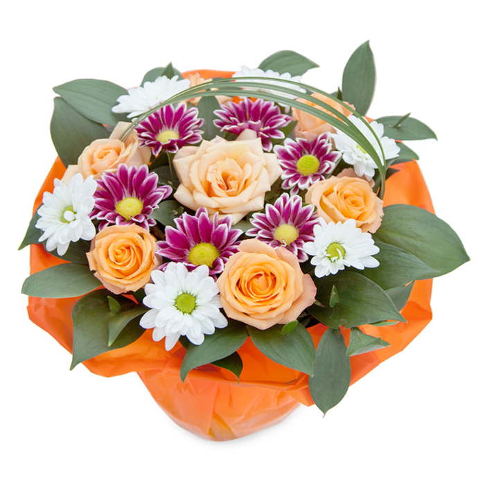 Brimming with colour and artistry, this top-view bouquet encapsulates the creative heart of Archway Flowers, known across N19 for their attention to freshness and detail. Central to the bouquet, carefully layered roses display gradients from gentle peach to glowing orange, each bloom unfolding its petals to showcase both softness and vibrancy. Interwoven among the roses, clusters of white daisy-style chrysanthemums reveal delicate radiance with their circular petals and light green centres, while deep magenta-purple chrysanthemums intensify the palette with their imagery reminiscent of Archway's local art scene. Bold, verdant foliage fills the base and spaces between blooms, giving the arrangement its fullness and tactile richness, just as Whittington Park provides a green lung at the area's heart. A slender arc of bear grass curves gently above the bouquet, invoking a playful sense of movement. The whole ensemble is elegantly wrapped in a crinkly orange tissue or cellophane, seamlessly blending with the warm rose tones and suggesting the anticipation of celebration or thoughtful gifting. Whether chosen for a birthday, a warm welcome, or a heartfelt thank you, this bouquet channels the spirit and beauty of Archway's vibrant neighbourhood.