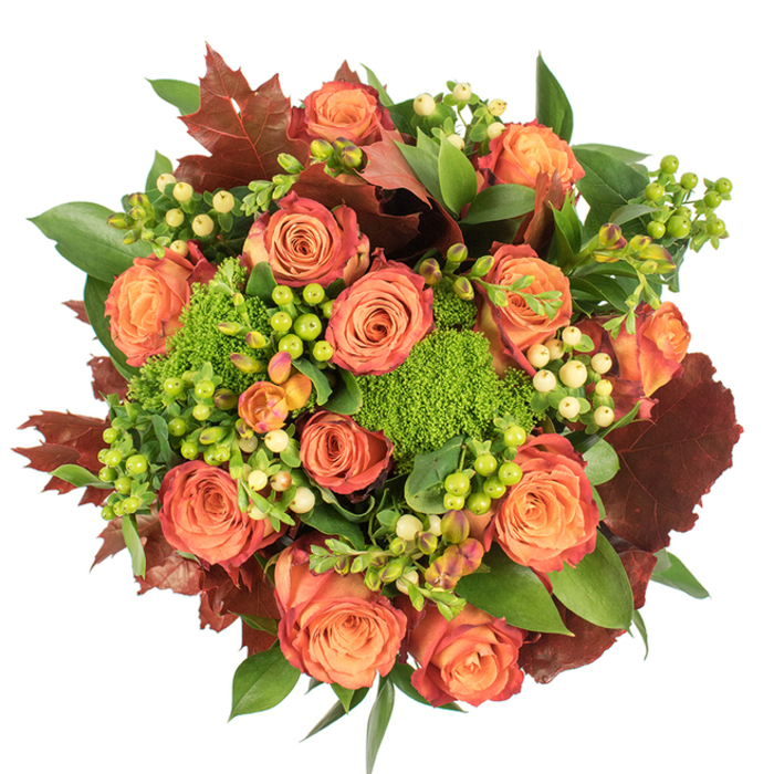 This circular, top-down floral composition is densely arranged to celebrate the textures and colours of fall while remaining refined and harmonious. Large, fully opened roses dominate: their cores glow with warm peach and coral, graduating gently outward to deeper orange and russet tones, some outer petals catching a rusty-red wash that adds natural depth. Interlaced with these classic roses are groups of small, smooth hypericum berries in contrasting tones-vivid limey green alongside pale cream and soft yellow-creating points of interest that punctuate the palette. The unmistakable, plush clusters of Green Trick dianthus offer a fresh, moss-like texture that balances the roses' soft velvety faces. Deep burgundy, lobed leaves-resembling autumnal maple or oak-are placed with deliberate rhythm, their darker, slightly textured surfaces grounding the composition while a steady underlayer of glossy green foliage supplies fullness and buoyancy.Under soft, even lighting the materials read clearly: velvety petals, glossy berries, textured green mounds and rustic foliage. The bouquet conveys a warm, harvest sensibility suited to dining tables, seasonal displays, or thoughtful autumn gifts. Sourced and hand-tied with an eye for seasonal character, this arrangement would sit comfortably in homes near Highgate, Holloway Road and the surrounding Archway neighbourhood, where its mix of scent, colour and texture echoes local leafy walks and market-season gatherings.