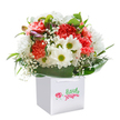 A breath of cheerfulness radiates from this generous bouquet, crafted with precision by expert florists in Archway and nestled within a white square gift bag-ready to bring colour to celebrations or simple acts of kindness. Ruffled coral and peach carnations set a lively, sunlit tone, their layered petals full of character. Buoyant white daisies, marked by bright yellow-green centers, stand beside, their faces turned upward like spring blooms spotted around local green spaces. Baby's breath weaves its airy magic throughout, contributing a gentle softness as delicate as the morning mist rolling over Highgate Hill. Glossy, deep green leaves provide a strong and elegant backdrop, embracing each stem and enhancing the sense of abundance. Discreet touches of purple-tinged buds add a spark of curiosity and freshness, quietly suggesting new wonders ahead. Arranged in a full, rounded composition, the bouquet glows with freshness-making it ideal for a birthday surprise, anniversary, or a heartfelt delivery to brighten a flat on Tollington Way. The clean-lined gift bag, paired with soft, natural light, allows every bloom to shine, truly reflecting the care and pride that define Archway's floral artistry.