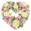A lovingly arranged heart-shaped funeral wreath appears against a crisp white background, its soft pastel palette and flowing outline creating an atmosphere of peace and reflection. The entire surface of the heart is covered in flowers, leaving no gaps, so the shape feels plush and inviting rather than stark. Creamy ivory and pale yellow roses are spaced thoughtfully around the design, their velvety petals forming elegant, full blooms that feel both gentle and steadfast, much like the enduring affection they are meant to represent. Between these roses, clusters of pastel pink carnations add volume and a distinctly ruffled texture, their frilled petals overlapping in soft waves. Deeper magenta and mauve-pink lisianthus blooms are woven among them, their slightly open, trumpet-shaped flowers lending a subtle richness of tone and a hint of movement, like quiet conversation at a wake or memorial gathering. Silvery-green eucalyptus foliage curls around and through the flowers, its rounded leaves and soft hue outlining the heart and bringing a restful, natural element reminiscent of Archway's green pockets and nearby Highgate Wood. Small yellow-green buds peek from within the arrangement, symbolising gentle hope amid sorrow. The composition feels balanced and harmonious, with the denser placement of blooms creating a luxurious, comforting look. This heart-shaped tribute is perfectly suited for services and funerals in Archway, whether delivered to a local church, crematorium, or family home, offering a visual message of love, remembrance, and sympathy when words may be difficult to find. The neutral white background keeps the viewer's focus entirely on the emotion expressed through the flowers.